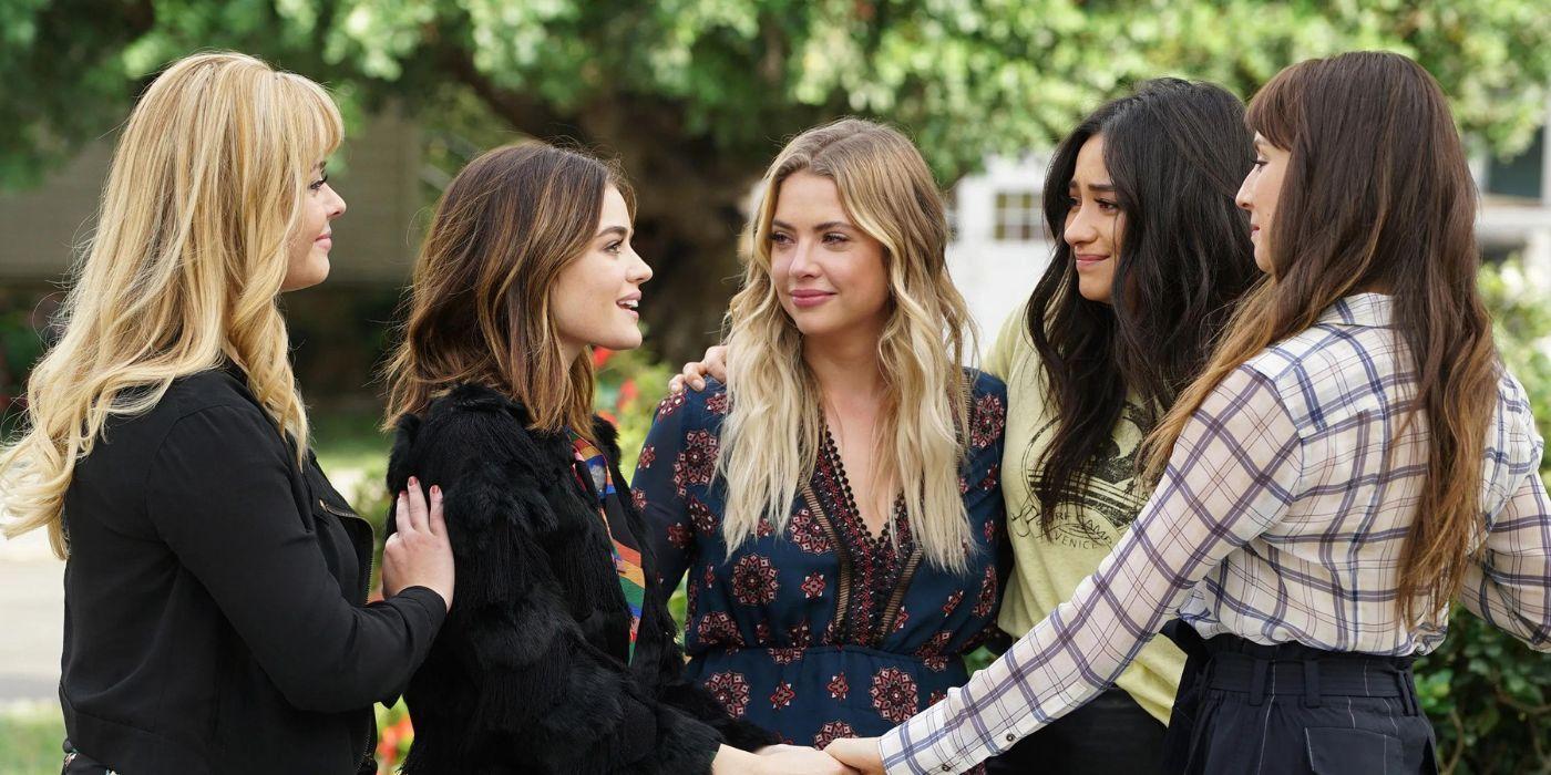 The girls of Pretty Little Liars, Lucy Hale's Aria, Ashley Benson's Hanna, Shay Mitchell's Emily, Troian Bellisario's Spencer, and Sasha Pieterse's Alison, hugging and looking at each other with smiles on their faces in the series finale.