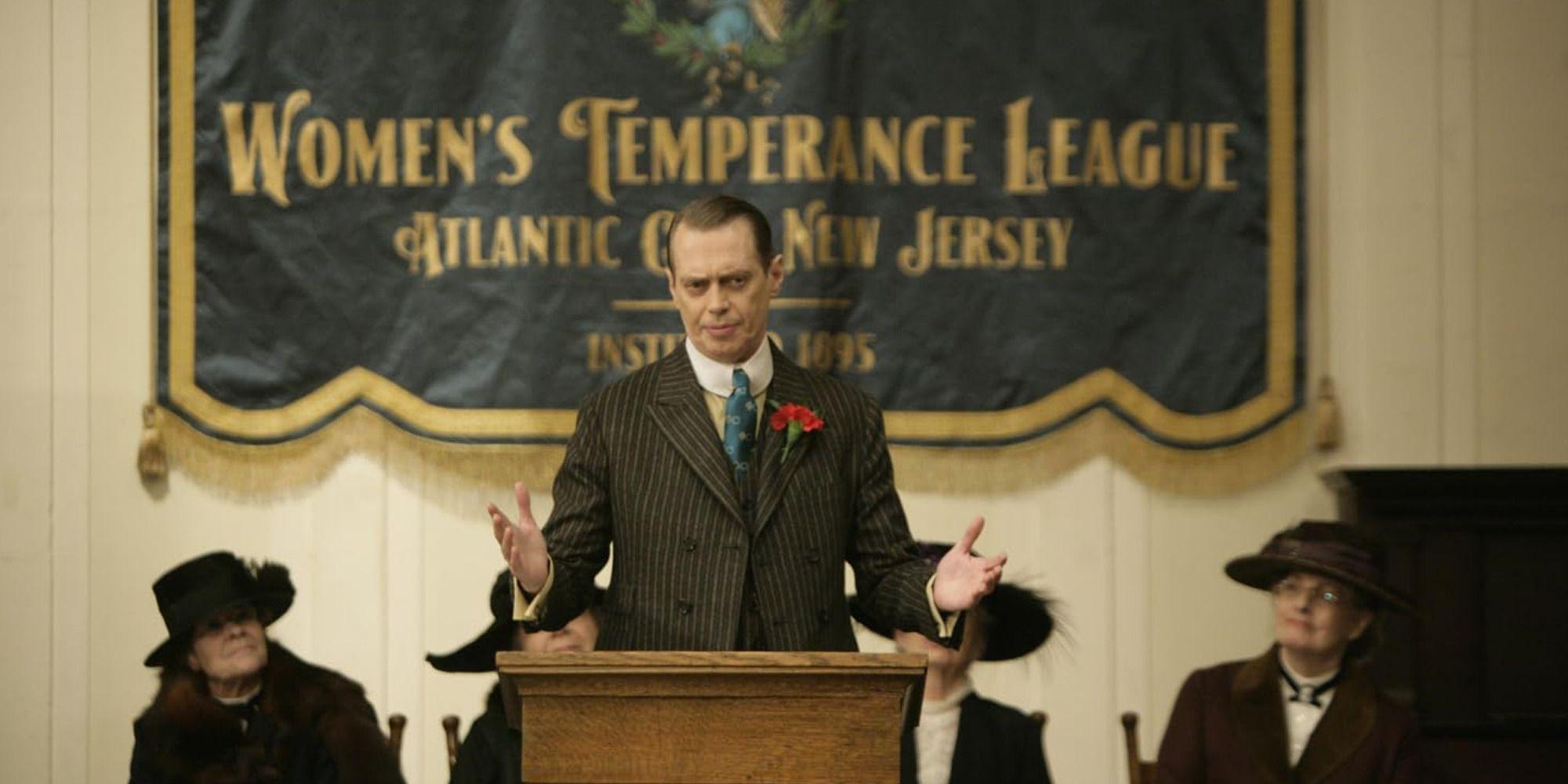Nucky Thompson speaking at an assembly, wearing an elegant suit